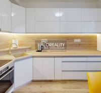 White kitchen with wood-patterned flooring in a 2-room apartment with modern lighting.
