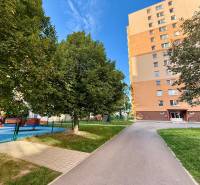 Apartment building on L. Novomeského in Senica with a playground and trees in the surroundings.