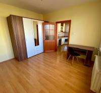 Bedroom in a 3-room apartment with wood-patterned flooring, a wardrobe, and a desk.
