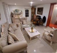 Living room with elegant furniture, a mirror, and a clock in a family house.