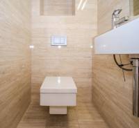 A bathroom in a 3-room apartment with a toilet and tasteful beige tiles.