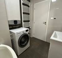 Bathroom in a 3-room apartment with a washing machine, sink, and radiator.