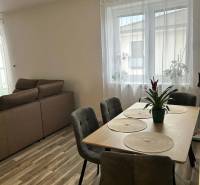 Dining table with chairs, floor with wooden decor, sofa in a 3-room apartment.