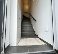 Entrance area with dark tiles and stairs in a 3-room apartment.