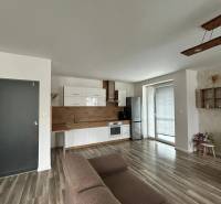 Living room with a kitchen unit and a wooden decor floor in a 3-room apartment.