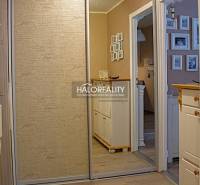 A hallway in a 2-room apartment with a sliding wardrobe and a floor with a wooden decor.