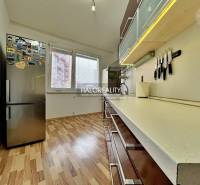The kitchen of a 3-room apartment with a wooden decor floor and modern appliances.