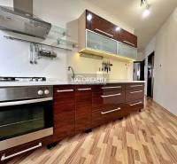 Kitchen in a 3-room apartment with wood-patterned flooring, spacious cabinets, modern appliances.