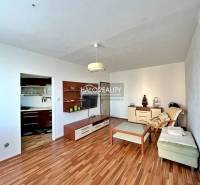 Living room with wood-patterned flooring in a 3-room apartment.