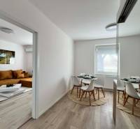Dining area with a round table in a 2-room apartment with a wooden decor floor.