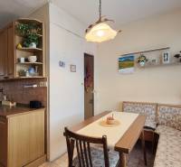A kitchen in a 2-room apartment with a corner bench, wooden decor, and rustic lighting.