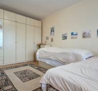 Two beds, a white wardrobe, wall decorations, a carpet in a 2-room apartment.