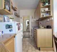 A kitchen in a 2-room apartment with a wooden decor and white walls.