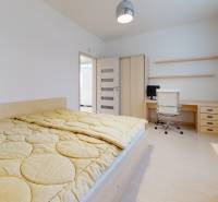 A bright bedroom with a desk and chair in a 5 or more room apartment.