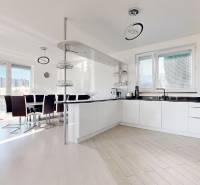 A kitchen in a 5 or more room apartment with a wood-patterned floor and a dining area.