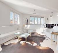 A bright living room in a 5 or more bedroom apartment with sofas, a glass table, and chess.
