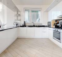 A kitchen in a 5 or more room apartment with white cabinets and a wood-patterned floor.