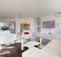 A living room in a 5 or more room apartment with white furniture and decor.