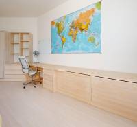 A student room in a five or more bedroom apartment with a world map and a wooden decor floor.