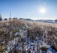 A snowy plot in Mlynica with dwellings in the background, ideal for living.