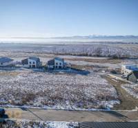 Mlynica: Lands - housing with snow-covered fields and houses, surrounded by forests and roads.