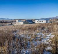 Residential plots in Mlynica with panoramic views and modern buildings in the background.