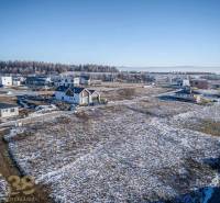 Plots - housing in Mlynica with a view of snow-covered mountains and houses on the slope.