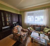 A living room of a family house with a colorful couch and a dark wall unit.