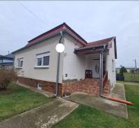 A family house in Hurbanovo with a red roof and a front garden with a lawn.