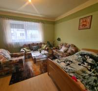 Living room in a family house with a sofa, carpets, and a decorative painting on the wall.