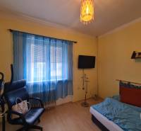 A room in a family house with exercise equipment, a chair, and a television.