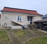 A family house in Hurbanovo with a red roof and an outdoor seating area in the garden.