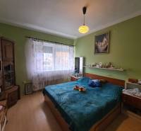 A bedroom in a family house with a wooden decor floor and a bed.
