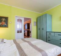 A bright bedroom with green walls, a wardrobe, and a painting in a 4-room apartment.