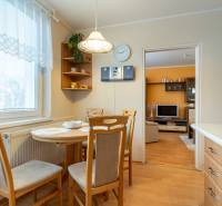 Dining area in a 4-room apartment with a wooden decor floor, connected to the living room.