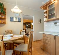 A kitchen in a 4-room apartment with a wood-decor floor, wooden furniture, and a dining table.