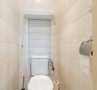 A small bathroom in a 4-room apartment with a toilet and tiled walls.