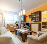Living room in a 4-room apartment with a sofa, armchairs, and a wooden decor floor.