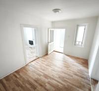A room in a family house with a wooden decor floor and simple furnishings.