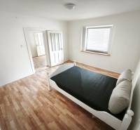 A bright room with a bed, a floor with wood decor, in a family house.