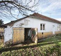 A family house in Lúčnica nad Žitavou with a bright facade and a garden on a sunny day.