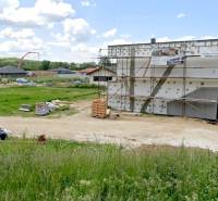 A residential building plot in Modrovka with an unfinished building and surroundings in the background.