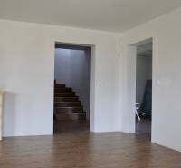 Interior of a family house with a fireplace, staircase, and floor with wood decor.