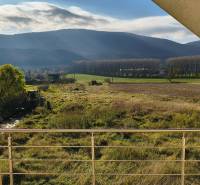 A view from a family house in Buková of the landscape with trees and a field.