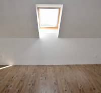 Attic room with a window and a wooden decor floor in a family house.