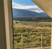The view from the family house in Buková offers impressive forests and fields beyond the railing.