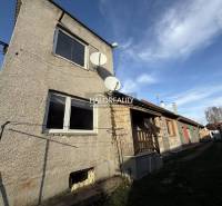 A family house in Chynorany with satellites and a garden, next to other houses.