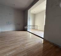 A room in a family house with a wooden decor floor and simple walls.