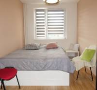 Bedroom in a 3-room apartment with a bed, chairs, and a wooden decor floor.