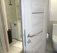 Bathroom in a 3-room apartment with a shower, washing machine, and toilet.